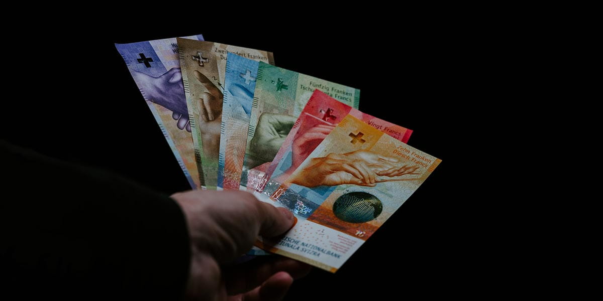 eine Hand die chf Banknoten hält